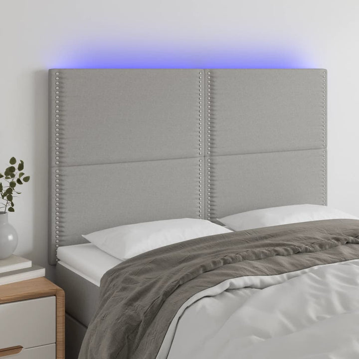 sengegavl med LED-lys 144x5x118/128 cm stof lysegrå