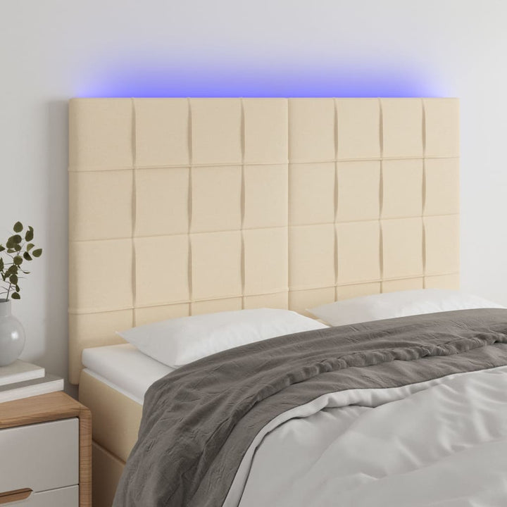 sengegavl med LED-lys 144x5x118/128 cm stof cremefarvet