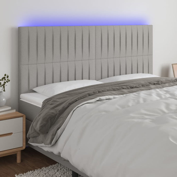 sengegavl med LED-lys 180x5x118/128 cm stof lysegrå