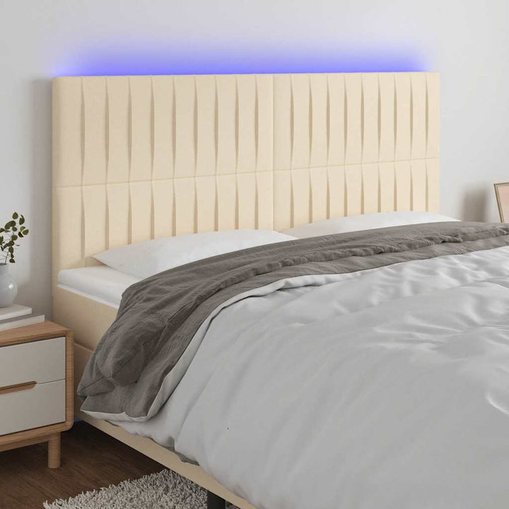 sengegavl med LED-lys 180x5x118/128 cm stof cremefarvet