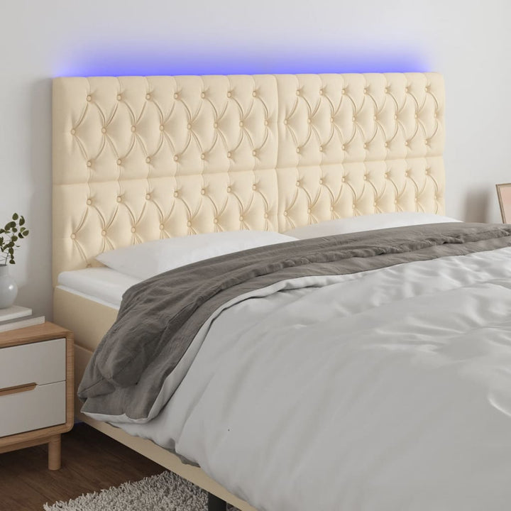 sengegavl med LED-lys 180x7x118/128 cm stof cremefarvet