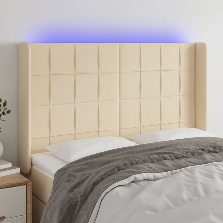 sengegavl med LED-lys 147x16x118/128 cm stof cremefarvet