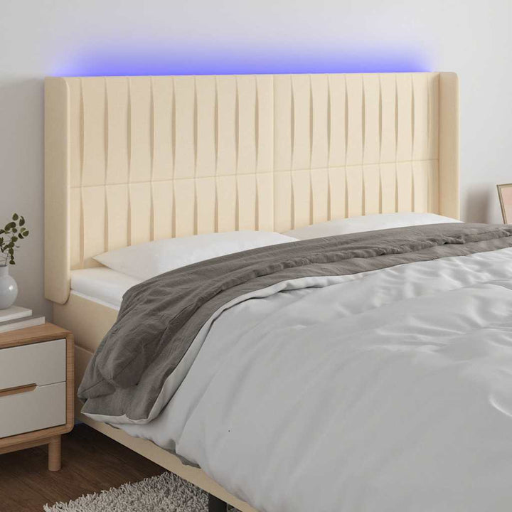 sengegavl med LED-lys 163x16x118/128 cm stof cremefarvet