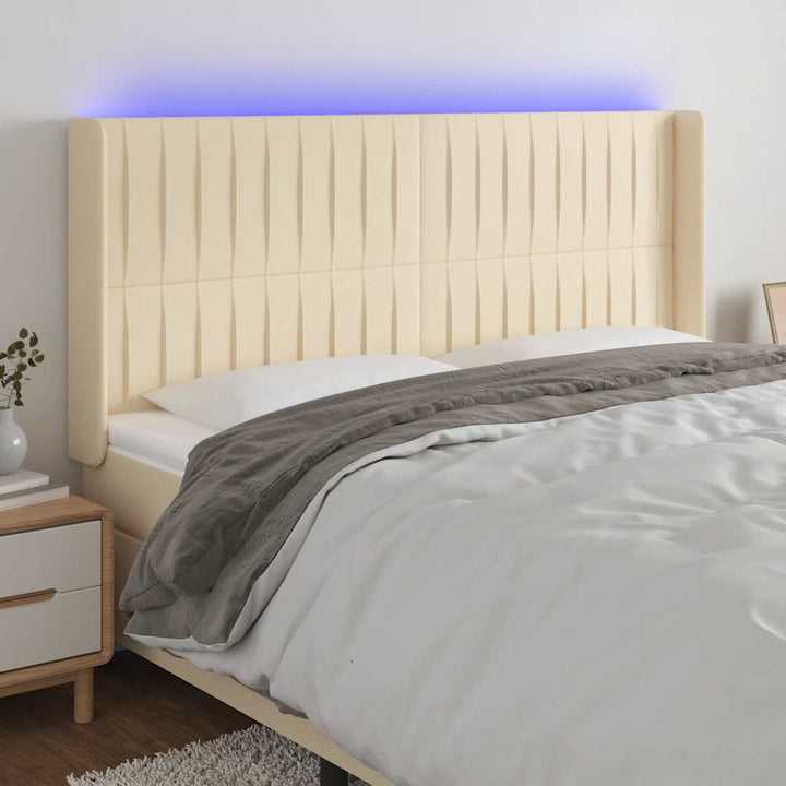 sengegavl med LED-lys 203x16x118/128 cm stof cremefarvet