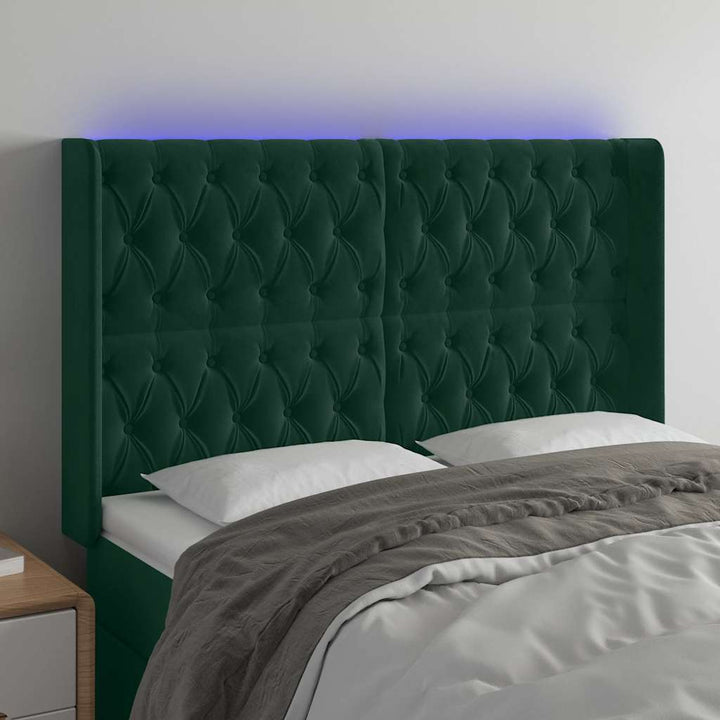 sengegavl med LED-lys 147x16x118/128 cm fløjl mørkegrøn